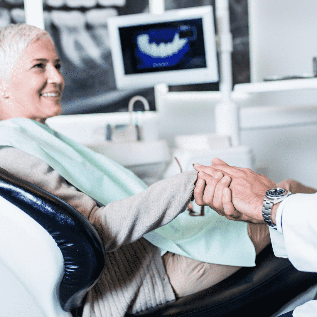 A woman holding hands with another person in an office.