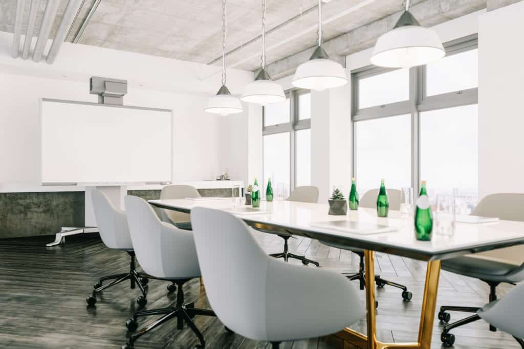 A long table with chairs and green bottles on the top of it.