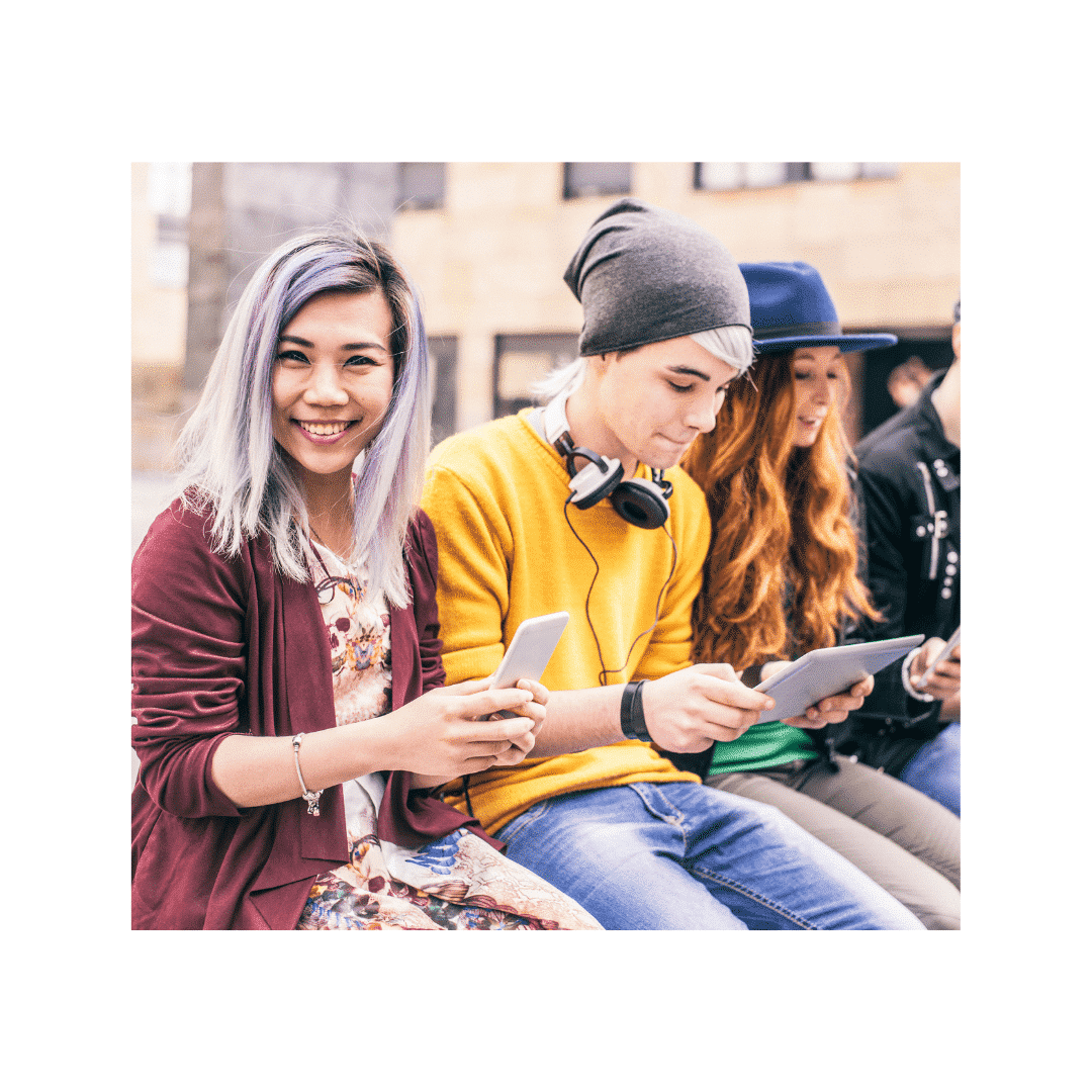 A group of people sitting on steps looking at their phones.