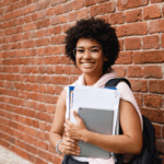 A woman holding papers and smiling for the camera.