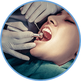 A woman getting her teeth cleaned by dentist.