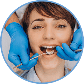 A woman getting her teeth checked by an dentist.